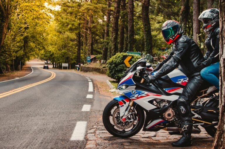 a couple of people ride on a motorcycle down a street