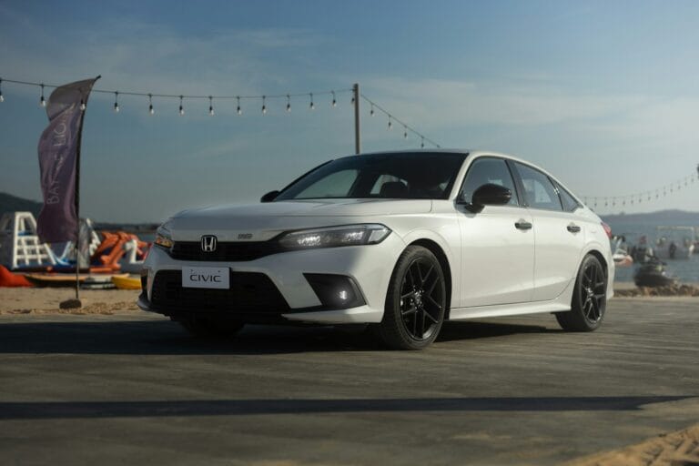 a white car is parked on the beach