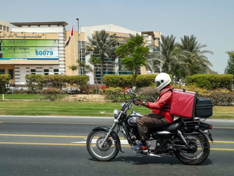 a man riding a motorcycle down a street