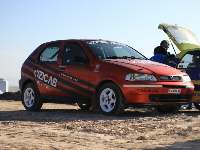 a red car with a surfboard on top of it