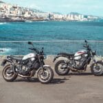 two motorcycles parked next to each other in a parking lot