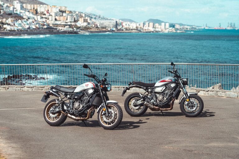 two motorcycles parked next to each other in a parking lot